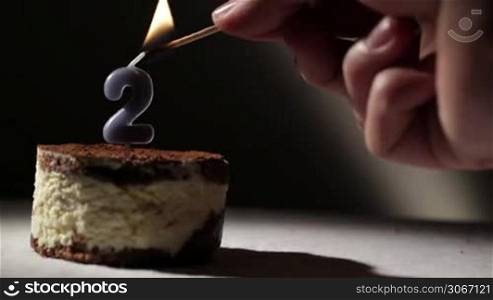 Candle two in tiramisu cake. Birthday vintage background.