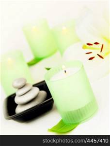 Candles and balanced zen spa stones with lily flower, relaxation vacation concept