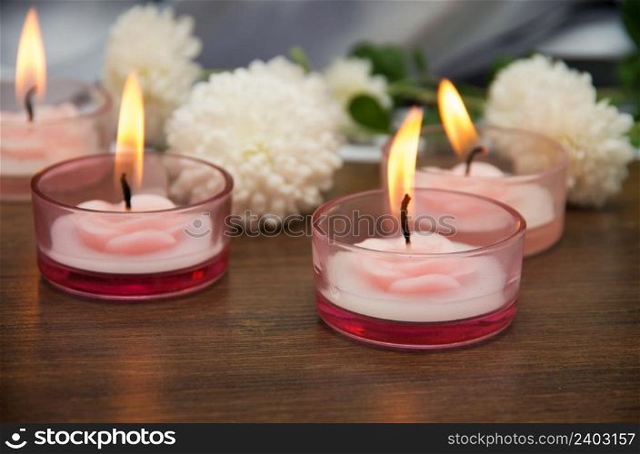 Candles and flowers on wooden table