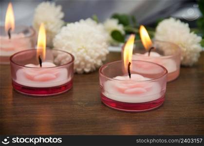 Candles and flowers on wooden table