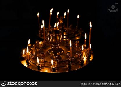 Candles burning over dark background in a church
