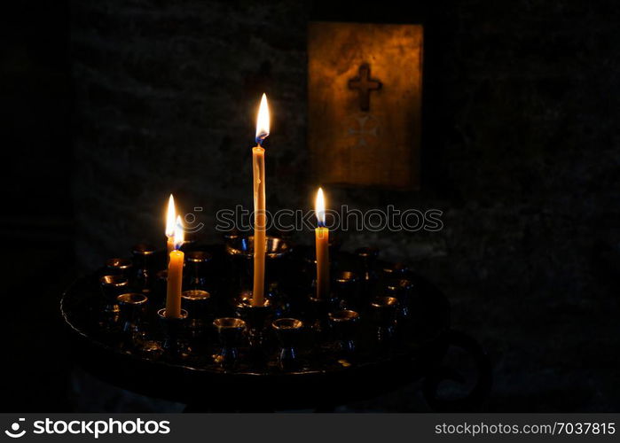 Candles burning over dark background in a church