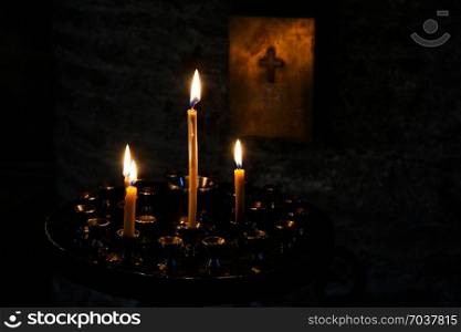 Candles burning over dark background in a church