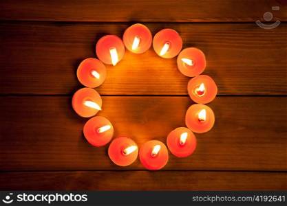 candles glowing in circle shape on golden wood background