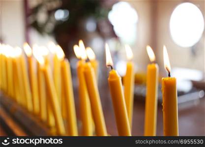 Candles light of burning at temple in abstract candles background for Concept design.