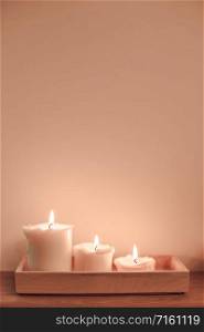 Candles lights in minimal composition on wall copy space background. Scandinavian hygge style pink toned