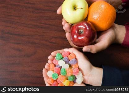 Candy and fruit being held