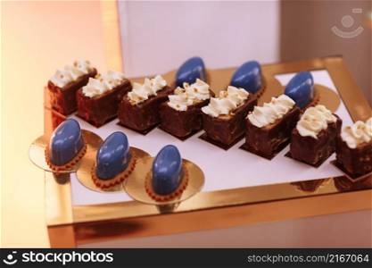 Candy bar on wedding party with a lot of different candies, cupcakes, souffle and cakes on golden plate. Candy bar on wedding party with a lot of different candies, cupcakes, souffle and cakes on golden plate.