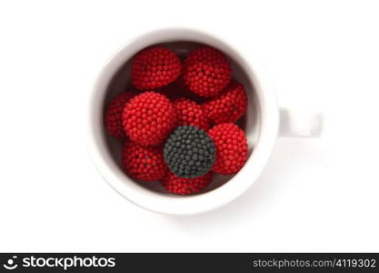 Candy berries and one different black in a coffe cup