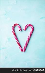 Candy cane making a heart on a light blue background, Candy cane heart Christmas background top view with copy space. Merry Christmas,xmas,holiday, Valentines day concept space for text. Candy cane making a heart on a light blue background, Candy cane heart Christmas background top view with copy space. Merry Christmas,xmas,holiday, Valentines day concept