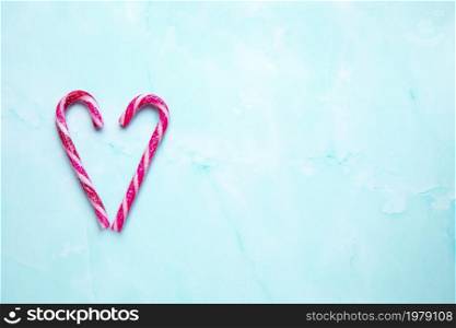 Candy cane making a heart on a light blue background, Candy cane heart Christmas background top view with copy space. Merry Christmas,xmas,holiday, Valentines day concept space for text. Candy cane making a heart on a light blue background, Candy cane heart Christmas background top view with copy space. Merry Christmas,xmas,holiday, Valentines day concept