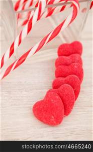 Candy canes and heart-shaped candies on a wooden grey background