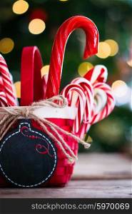 Candy canes in a basket on christmas background
