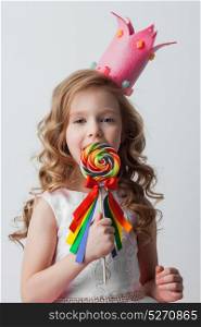 Candy princess girl. Beautiful little candy princess girl in crown holding big lollipop and smiling