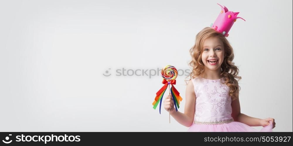 Candy princess with lollipop. Small princess girl in crown holds a large spiral decorated lollipop candy
