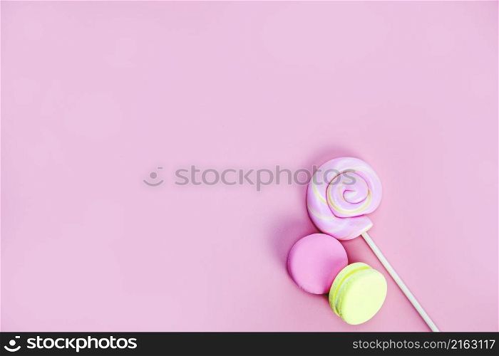 Candy sweets concept. Pink lollypop and donuts, macarons on pink background, copy space top view space for text. Candy sweets concept. Pink lollypop and donuts, macarons on pink background, copy space top view