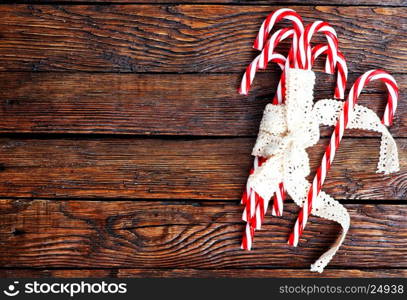 candycanes with white ribbon on the wooden table