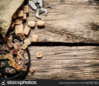 Cane sugar. On a wooden background. Top view. Cane sugar. On wooden background.