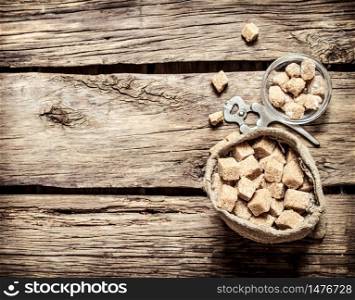 Cane sugar refined in the bag. On the wooden background.. Cane sugar refined in the bag. On wooden background.