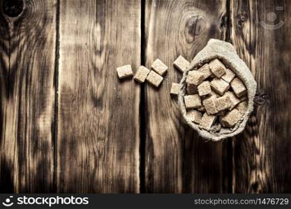 Cane sugar refined in the bag. On the wooden background.. Cane sugar refined in the bag. On wooden background.