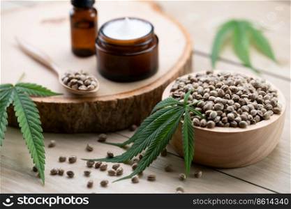 Cannabis and cosmetic concept features with set of CBD oil bottles, cream jar, and wooden bowl of hemp seeds. Legalized cannabis for skincare products.. Legalized cannabis for skincare product features with set of CBD oil bottles.