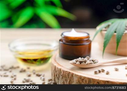 Cannabis and cosmetic concept features with set of CBD oil bottles, cream jar, and wooden bowl of hemp seeds. Legalized cannabis for skincare products.. Legalized cannabis for skincare product features with set of CBD oil bottles.