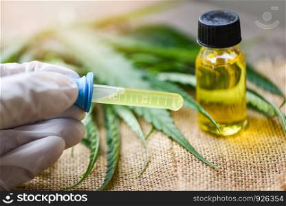 Cannabis oil in bottle products on sack background - THC and CBD oil extract from cannabis leaf marijuana leaves for Hemp medical healthcare natural selective focus
