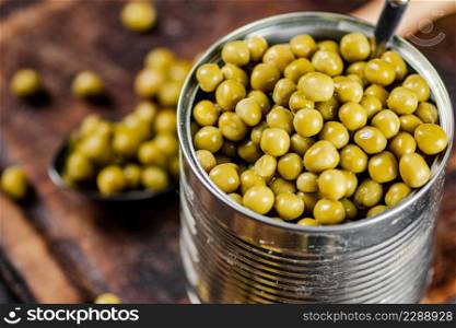 Canned green peas on a cutting board. Macro background. High quality photo. Canned green peas on a cutting board.