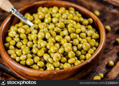 Canned green peas on a cutting board. Macro background. High quality photo. Canned green peas on a cutting board.