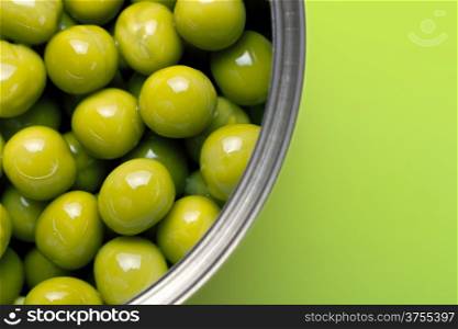 Canned peas on green background. Macro shot with copy space