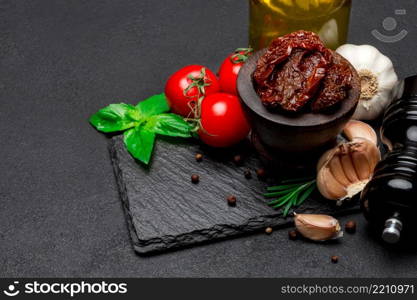 Canned Sundried or dried tomato halves in wooden bowl, dark concrete background. Canned Sundried or dried tomato halves in wooden bowl