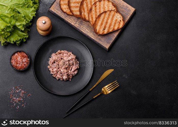 Canned tuna and croutons to make a delicious healthy sandwich with boiled egg, herbs and butter on a dark concrete background. Canned tuna and croutons to make a delicious healthy sandwich
