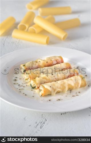 Cannelloni stuffed with ricotta on the white plate