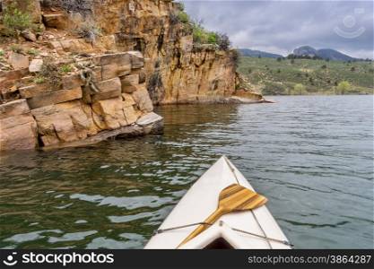 canoe and sandstone cliff - springtime paddling Horsetooth Reservoir near Fort Collins, Colorado