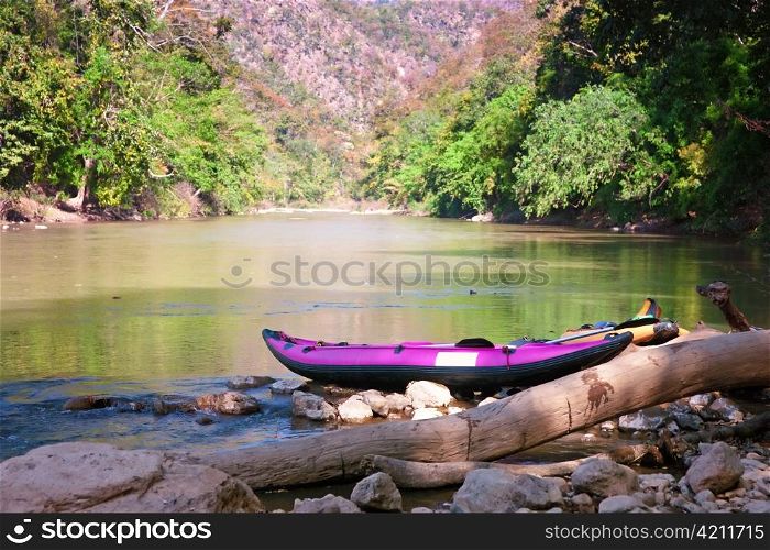 canoe on waters edge waiting for use in northern thailand