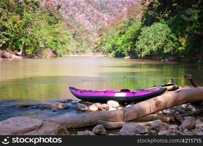 canoe on waters edge waiting for use in northern thailand