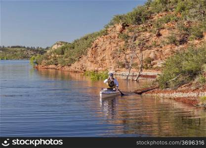 canoe paddler (senior male) on a mountain lake - Horsetooth Reservoir near Fort Collins, Colorado at springtime
