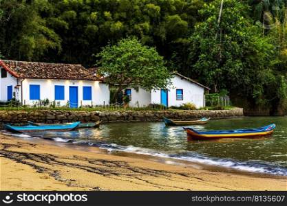 Canoes on the waters of the beach surrounded by the rainforest in Paraty at dusk. Canoes on the waters of the beach