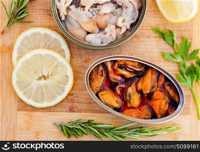 Cans of preserve on a wooden background with lemon and differents herbs