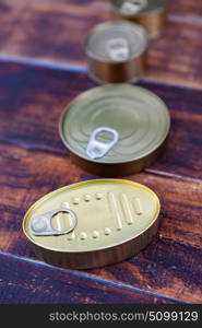 Cans of preserves on an aged wooden background