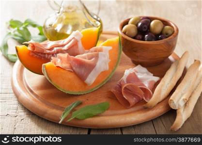 cantaloupe melon with prosciutto and olives. italian appetizer
