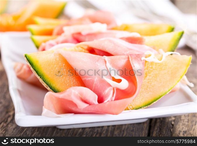 cantaloupe melon with prosciutto on a plate