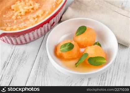 Cantaloupe-mint sorbet with fresh mint leaves in the white bowl