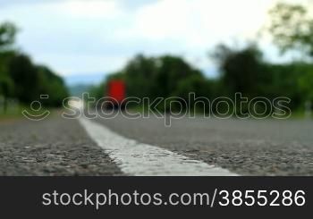 Canted shot of a cars passing by on a road