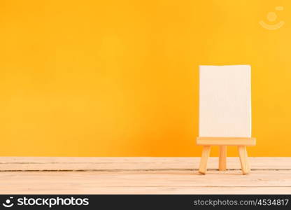 Canvas on a wooden table with an orange background