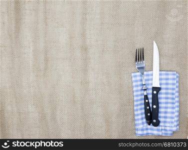 Canvas tablecloth, fork, knife for steaks and napkin. Is used to create a menu for a steak house. The background for the menu.