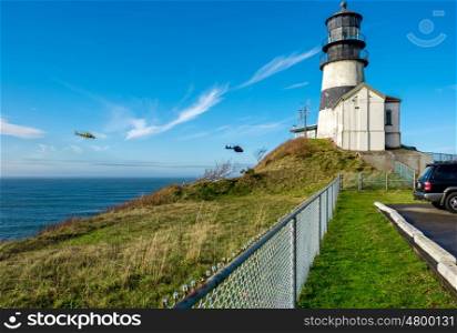 Cape Disappointment Lighthouse, built in 1856, Pacific coast, WA, USA. Coast guard helicopters in the sky.