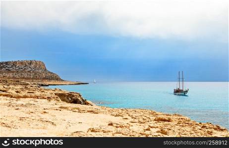 Cape Greco panorama with blue sea and yacht in the foreground, Agia Napa, Cyprus
