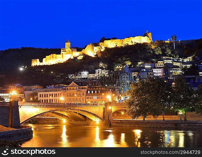 Capital of Georgia - Tbilisi at night against the dark blue sky