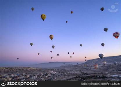 CAPPADOCIA, TURKY - 19 December 2019 : Aerial beautiful landscape view of balloons flight in the morning twilight sky background
